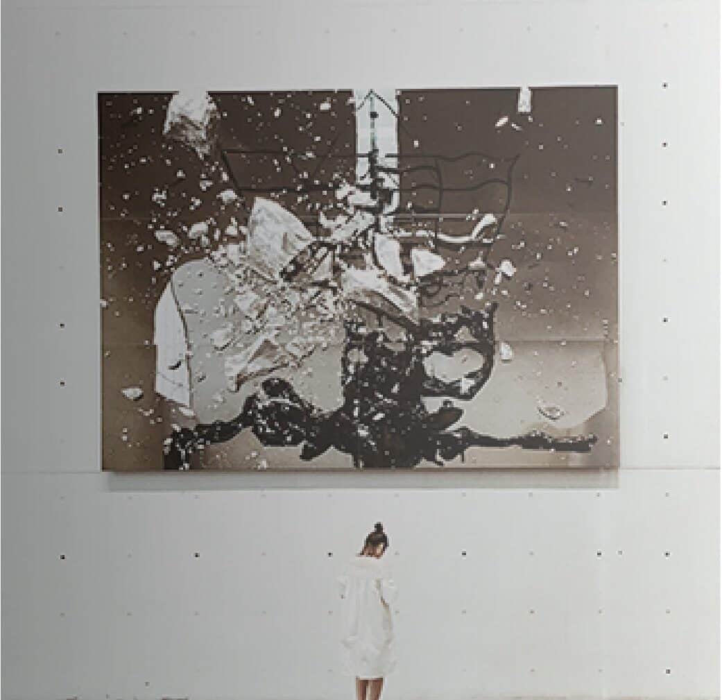woman in white dress near the artwork