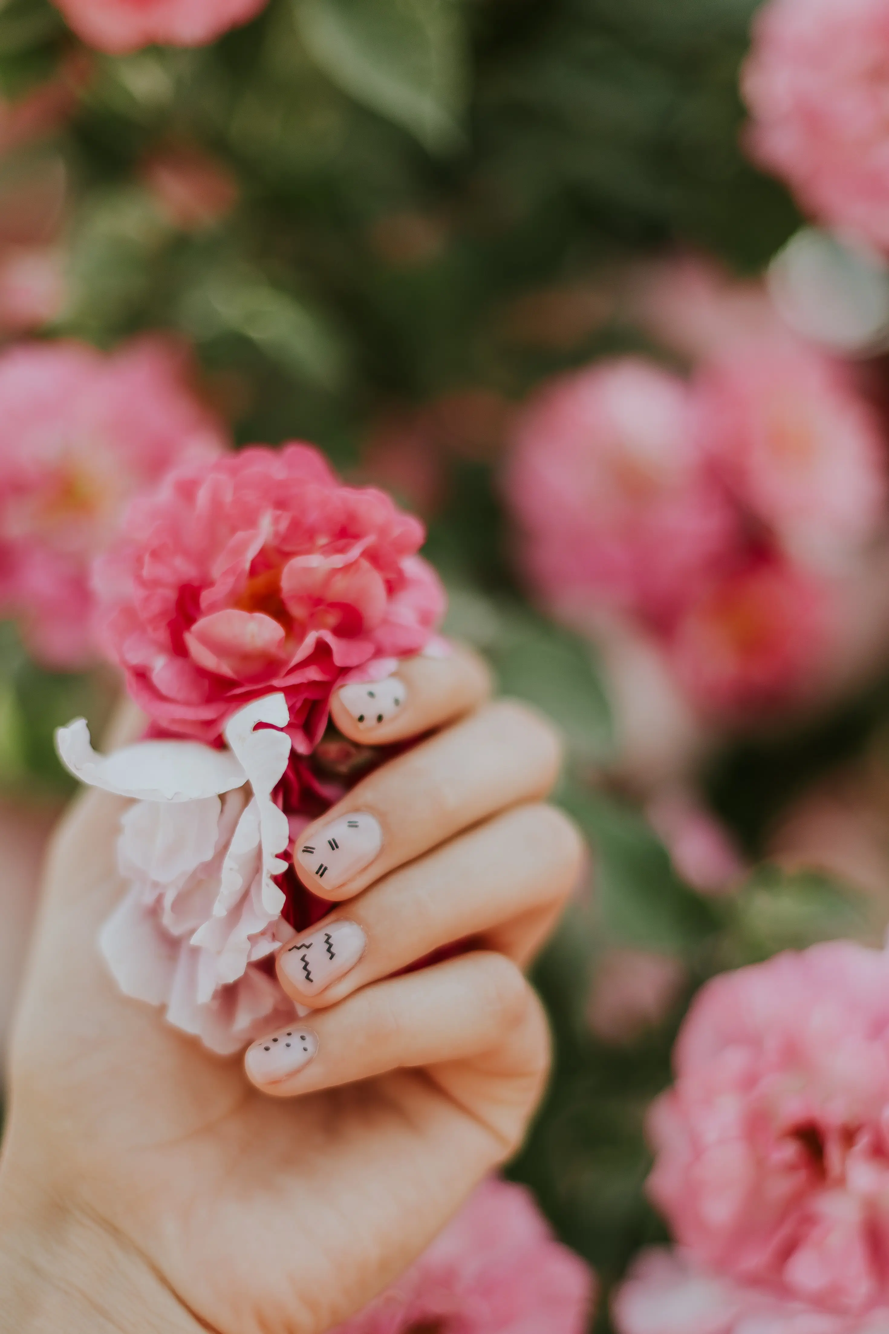 flower in hand with painted nails